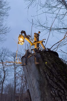 a wooden figure of a forester with a lantern on a tree. photo