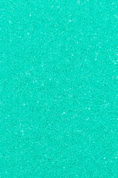 Turquoise color foam sponge porous abstract background. Extreme close-up view of detail synthetic textured material. Vertical composition for design, colored backdrop.