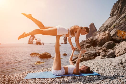 Woman sea yoga. Back view of free calm happy satisfied woman with long hair standing on top rock with yoga position against of sky by the sea. Healthy lifestyle outdoors in nature, fitness concept.