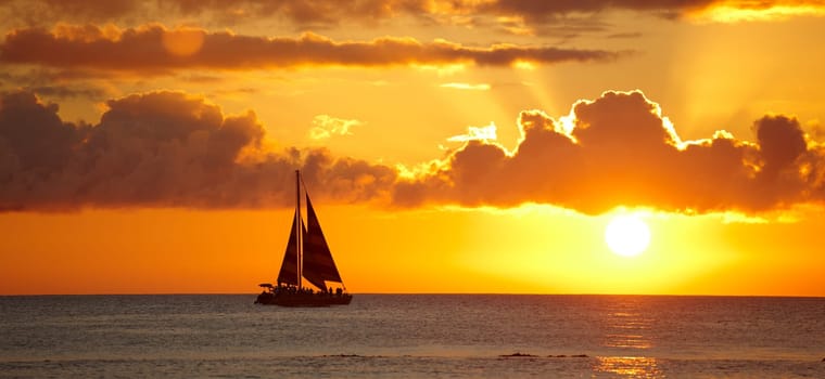 Boat, beach and sunset with clouds, water and ocean with Waikiki, Honolulu and Hawaii. Dusk, seaside and nature with environment or travelling with vacation and adventure with journey, summer or ship.