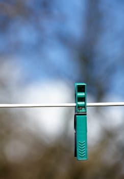 Sky, line and plastic peg or pin for clothes, outdoor and closeup of clip on rope to hang. Metal, vibrant and tool to fasten laundry to dry, clean and washing on string, backyard and sunshine.