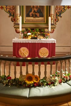 Christian, shrine or altar in church for religion, worship and spiritual space for Catholic ceremony or culture. Praise, god and painting of Jesus in chapel with candles and holy bible on table.