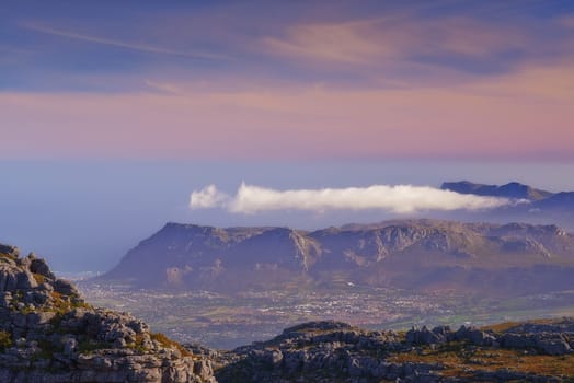 Mountains, color and natural landscape with cloudy sky, sunset and calm cliff at travel location. Nature, island and sustainable environment with earth, peace and pink tropical holiday destination.