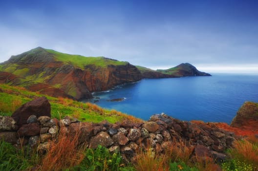 Mountain, ocean and nature on island with blue sky, summer plants and natural landscape at travel location. Sea, cliff and sustainable environment with earth, rock and tropical holiday destination.