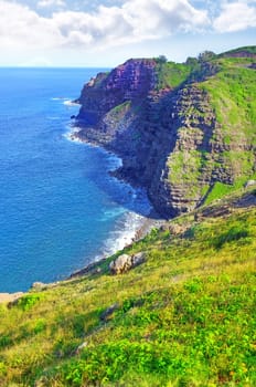 Mountain, island and ocean with green landscape, summer and calm water on peak at travel location. Nature, cliff and sustainable environment with earth, drone and sky on tropical holiday destination.