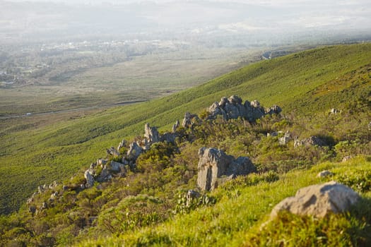 Mountain, fog and natural landscape with grass, rocks and calm field for travel location. Nature, hill and sustainable environment with earth, peace and holiday destination with planet conservation.