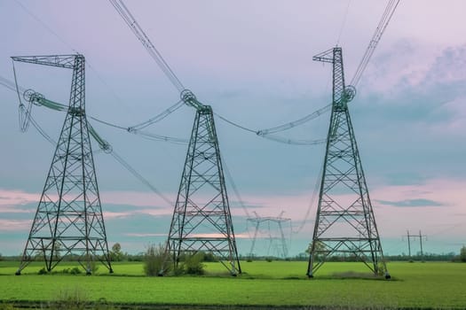 Group silhouette of transmission towers, power tower, electricity pylon, steel lattice tower at twilight. Texture high voltage pillar, overhead power line, industrial background. download
