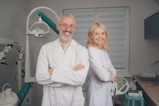 Male and female dental doctors wearing face sitting at his clinic. High quality photo