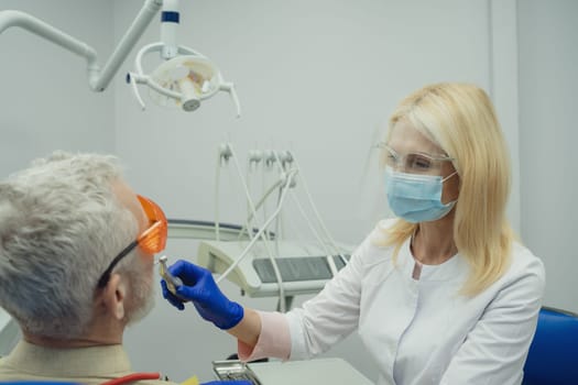 Male smiling during her dental treatment at dentist.