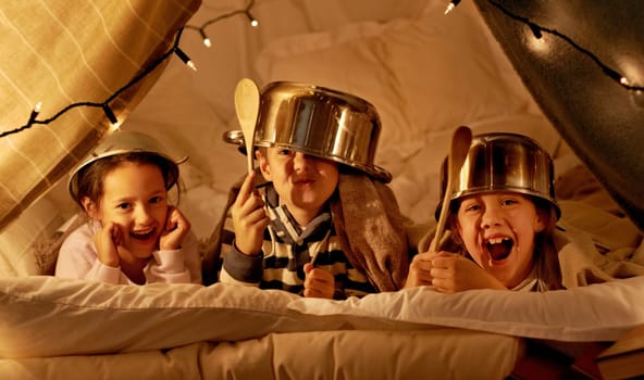 Tent, games and portrait of children at night in bedroom for playing and bonding together. Home, youth and happy kids with spoon, helmet pots and blanket fort for playful, imaginary and childhood fun.