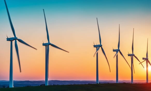 Wind turbines on the hillside at sunset. Windmills for electric power production