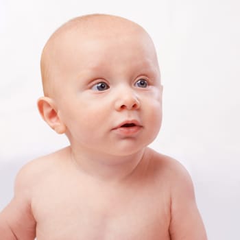 Young, cute and face of baby on a white background for child development, youth and growth. Curious, facial expression and closeup of isolated newborn for childhood, wellness and adorable in studio.