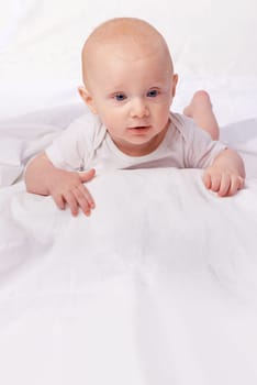 Bed, blanket and face of baby in studio on a white background for child development, care and growth. Sleep, leisure and isolated newborn rest, relax and nap for childhood, wellness and comfort.