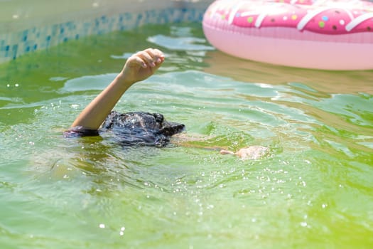 little girl in the green water of very dirty pool.