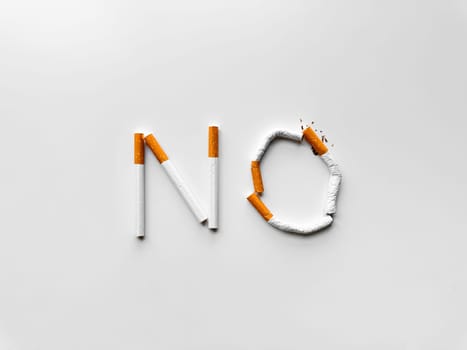 Word 'NO' made from broken cigarettes on white background, symbolizing smoking cessation and anti tobacco message. No tobacco day. High quality photo