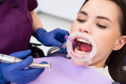 Professional dentist examines patients teeth in stomatology clinic.