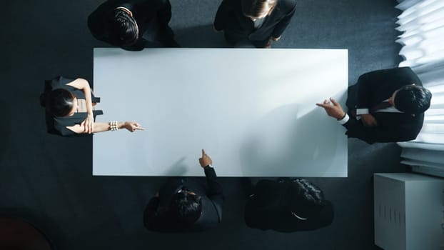 Top down aerial view of smart cooperate businessman discussing about marketing strategy. Diverse business group brainstorming idea startup project and financial plan at meeting room. Directorate.