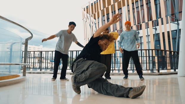 Hip hop team dance break dance while multicultural friend surrounded and clapping hands to cheer or encourage his friend to dance. Active and energetic street dance. Outdoor sport 2024. Endeavor.