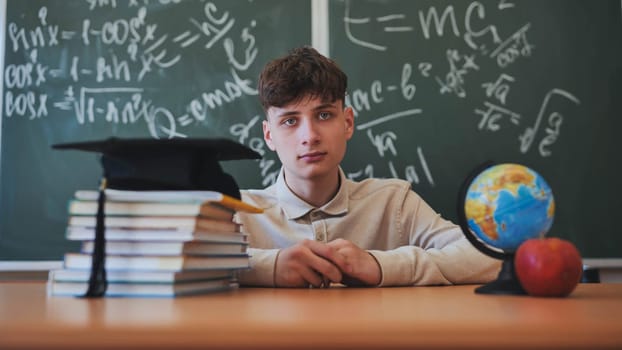 Portrait of smiling male student standing with hands in pockets in high school campus