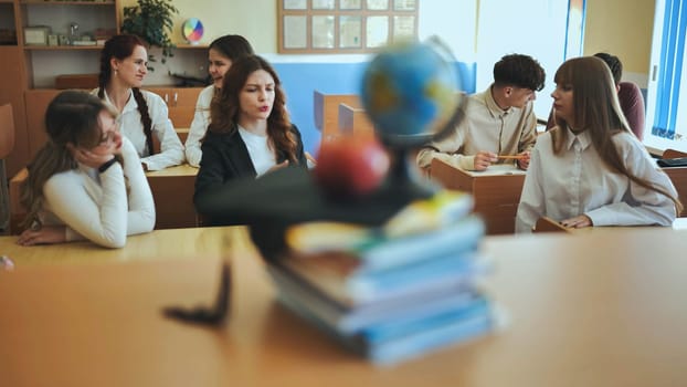 homework classroom study during pandemic COVID 19 coronavirus, remote learning, desk with pile of books, world map globe and face mask, back to school college university education concept