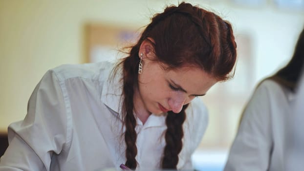 A high school student sits at her desk