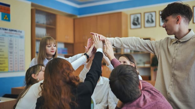 High school seniors join hands in class as a sign of working together