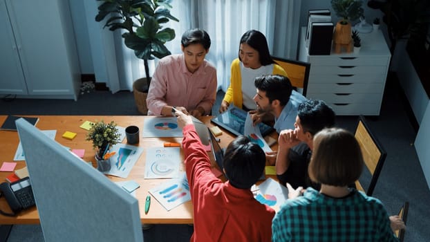 Top view of skilled business team discussing and talking about financial statistic to make decision for investment. Creative project manager looking at data analysis from laptop screen. Convocation.