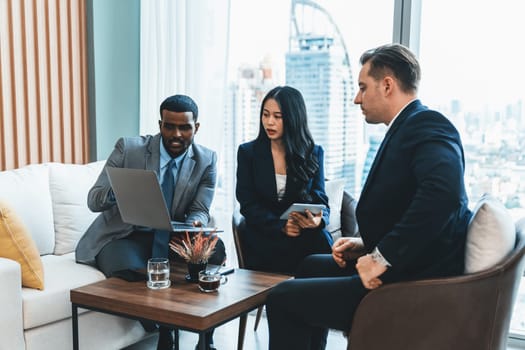 African businessman present start up project to expert investor. Group of multicultural business team solving problems, discussing business idea with skyscraper at modern business lounge. Ornamented