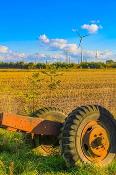 Tractor trailer left in the landscape with wind turbines in the background in Weddewarden Bremerhaven Germany.