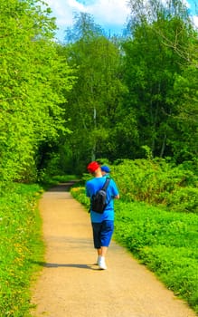 Young man walking with baby in his arms in forest park in Leherheide Bremerhaven Bremen Germany.