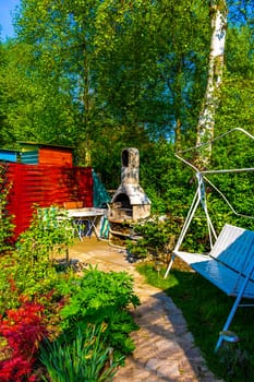 Green Garden with trees plants hut compost beds lawn and barbecue area in Leherheide Bremerhaven Bremen Germany.