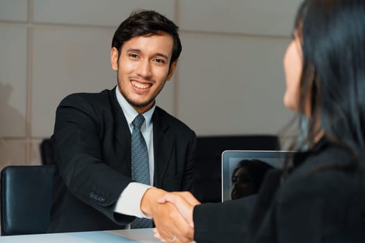 Business people agreement concept. Businessman and Asian businesswoman do handshake in the office. uds