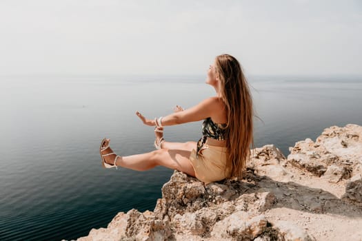 Woman travel sea. Happy tourist taking picture outdoors for memories. Woman traveler looks at the edge of the cliff on the sea bay of mountains, sharing travel adventure journey.