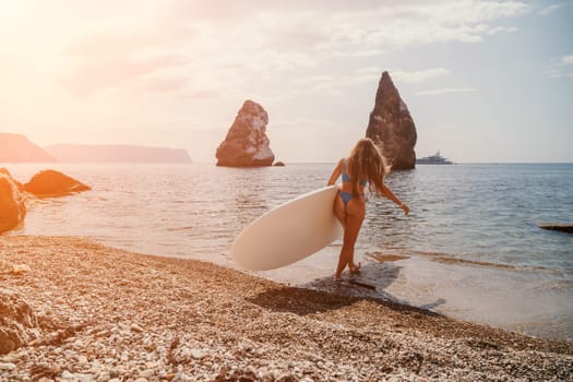 Close up shot of beautiful young caucasian woman with black hair and freckles looking at camera and smiling. Cute woman portrait in a pink bikini posing on a volcanic rock high above the sea