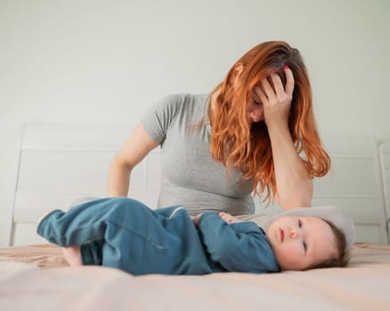 A woman sits on her child's bed and cries. Postpartum depression
