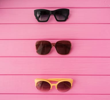 Summer abstract background mockup template free copy space for text pattern sample top view above on pink wooden board. blank empty area for inscription. Couple Stylish black sunglasses fashionable