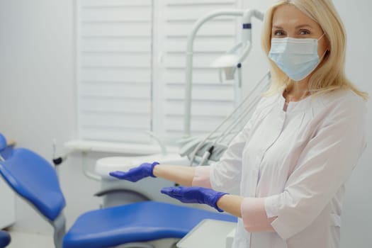 Woman working in dental clinic and doctor in background.