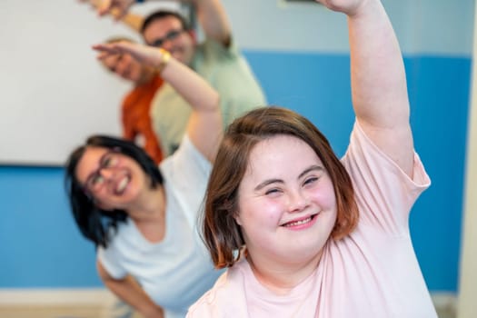 Happy group of people with special needs enjoying gymnastics stretching the back together