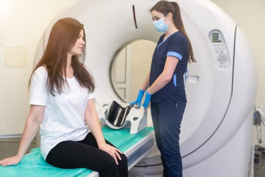 Radiologist with a female patient in the room of computed tomography.
