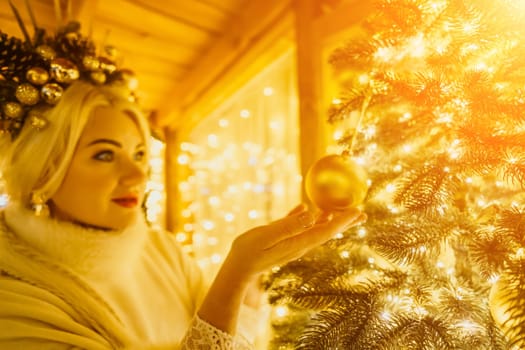 A Christmas tree with gold ornaments and lights. The tree is decorated with gold balls and is lit up with lights.