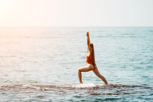 Woman sea yoga. Back view of free calm happy satisfied woman with long hair standing on top rock with yoga position against of sky by the sea. Healthy lifestyle outdoors in nature, fitness concept.