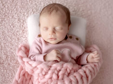 Baby Girl In Pink Outfit Sleeps During Newborn Photo Session In Studio