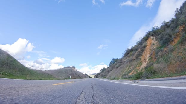 Vehicle is cruising along the Cuyama Highway under the bright sun. The surrounding landscape is illuminated by the radiant sunshine, creating a picturesque and inviting scene as the car travels through this captivating area.