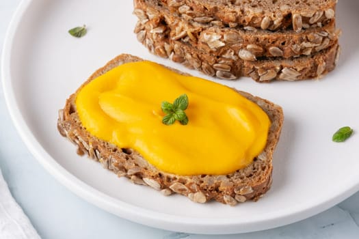 Sandwich with tasty pumpkin jam on table.