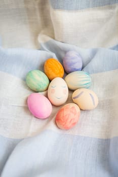 Painted multicolored Easter eggs, eggs painted with watercolors. A cute face in the middle of painted eggs. Easter card