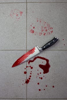 Bloody crime scene with knife evidence on the tile floor, traces of blood and the murder weapon lie at the crime scene