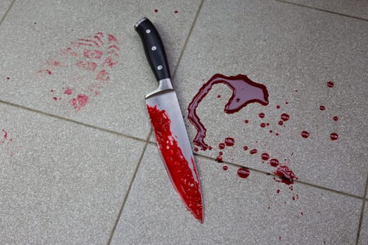 Crime scene with bloody knife and shoe print in blood, bloody footprints of the criminal on the tiled floor