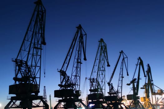 port cranes against the backdrop of a beautiful sunset.