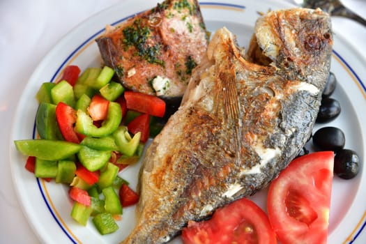 Fried river fish carcass with vegetables