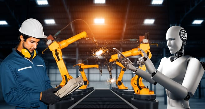 XAI Mechanized industry robot and human worker working together in future factory. Concept of artificial intelligence for industrial revolution and automation manufacturing process.